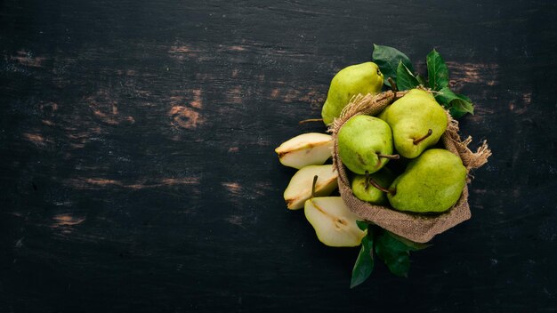 Pere fresche. Un grande set di pere. Frutta. Spazio libero per il testo. Su uno sfondo di legno nero. Vista dall'alto.