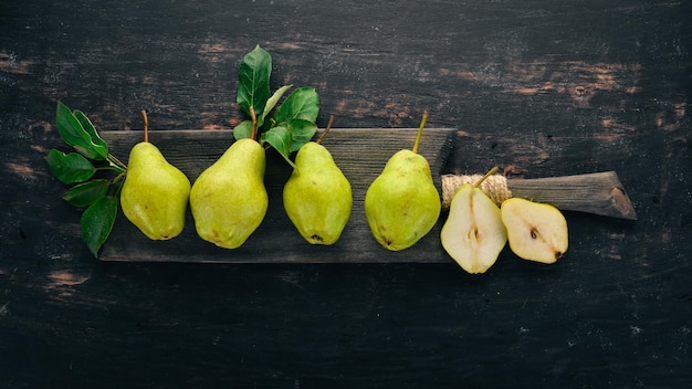 Pere fresche Un grande set di pere Frutta Spazio libero per il testo Su uno sfondo di legno nero Vista dall'alto