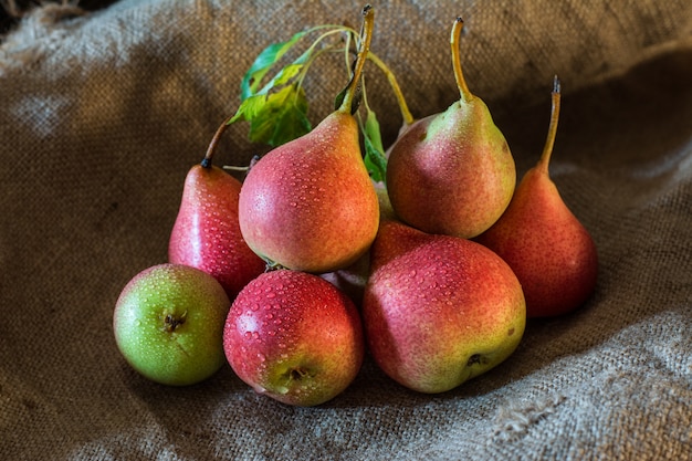 Pere rosse organiche mature fresche sulla tavola rustica, sfondo naturale, vegano, alimento di dieta, Vegeta