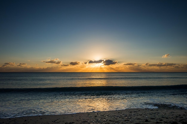 Perfetta vista sul mare fiammeggiante da una spiaggia al tramonto