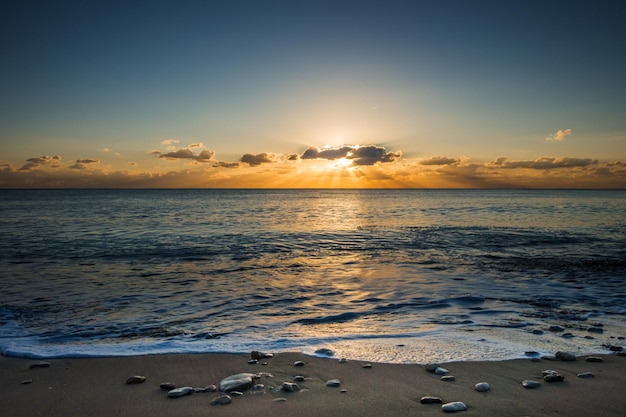 Perfetta vista sul mare fiammeggiante da una spiaggia al tramonto