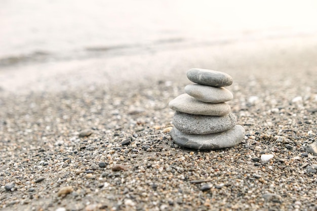 Perfetto equilibrio di una pila di ciottoli sulla riva del mare Concetto di equilibrio armonia e meditazione Aiutare o sostenere qualcuno per crescere o andare più in alto