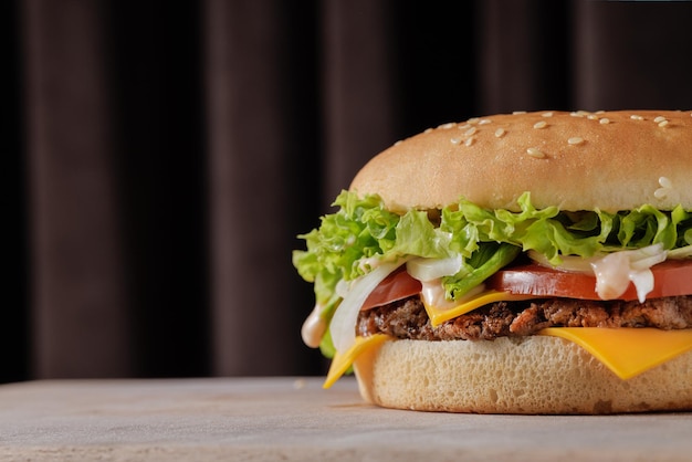 perfetto gustoso grande cheeseburger su tavolo di legno su sfondo marrone