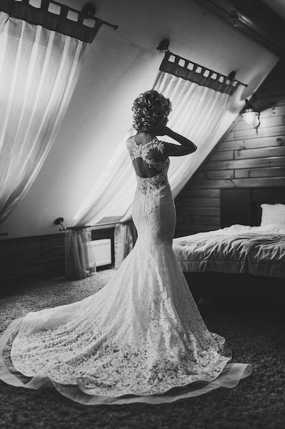 Perfetto modello di moda donna con bella acconciatura a casa Bella sposa stile Matrimonio ragazza in abito di lusso Vista posteriore Foto in bianco e nero