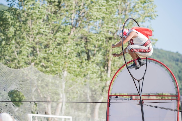 Performance del circo di strada Persona che si esibisce su un cerchio di fuoco che salta trapezio