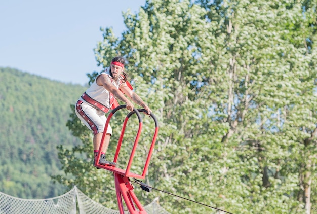 Performance del circo di strada Persona che si esibisce su un trapezio e guarda il pubblico