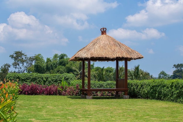 Pergolato in legno con tetto in paglia per rilassarsi nel giardino tropicale. Isola Bali, Ubud, Indonesia