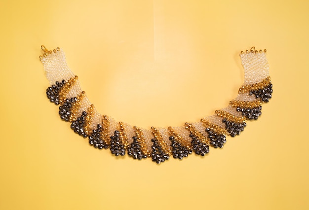 Perline, gioielli, collana di perline su sfondo giallo.