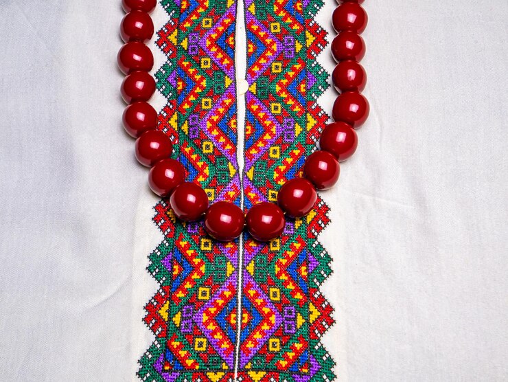 Perline rosse da donna sulla camicia ricamata ucraina