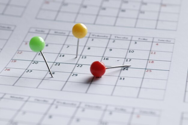 Perni multicolori su un primo piano del calendario. Data importante. Posto per il testo. Concetto di pianificazione.