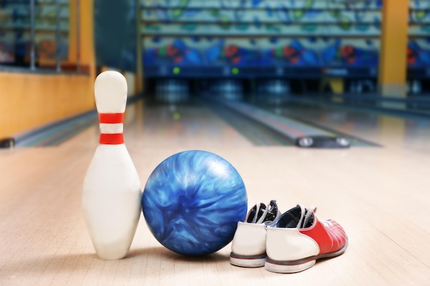 Perno a sfera e scarpe sul pavimento nel club di bowling