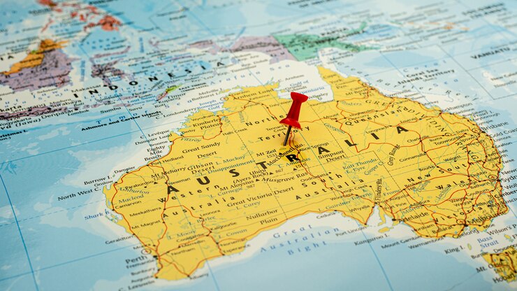 Foto perno rosso disposto selettivo alla mappa dell'australia. - concetto economico e di governo.