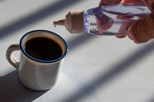 Persona addolcire il caffè con dolcificante liquido