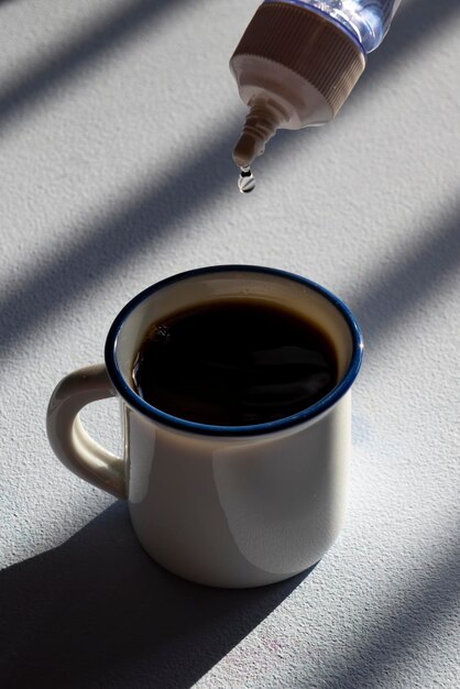 Persona addolcire il caffè con dolcificante liquido