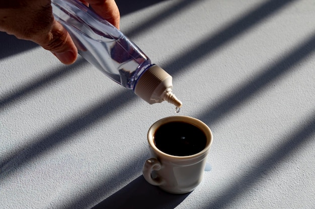 Persona addolcire il caffè con dolcificante liquido