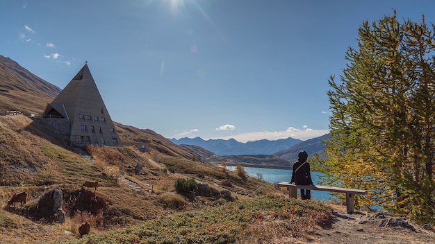 Persona che contempla il paesaggio alpino in autunno con il lago e le montagne