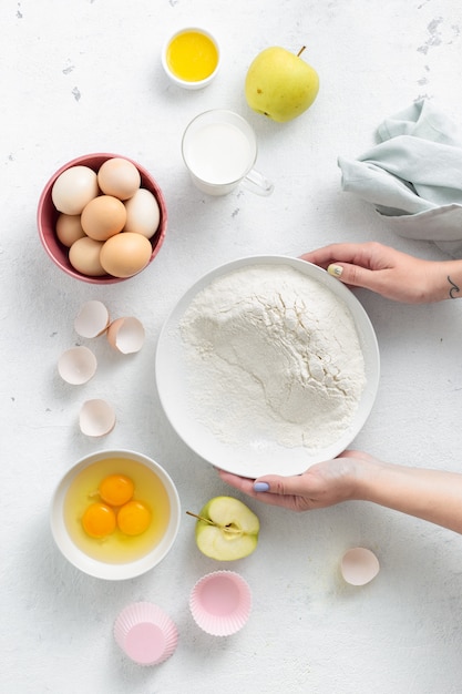 Persona che cucina dessert. Mani delle donne che preparano vista superiore della torta di mele. Ingredienti alimentari da forno