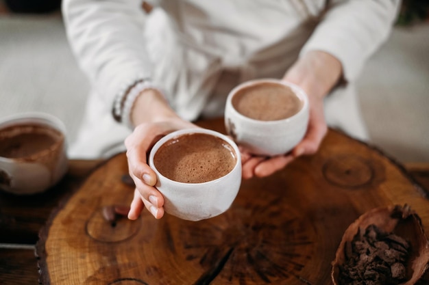 Persona che dà cacao cerimoniale in tazza di bevanda al cioccolato vista dall'alto