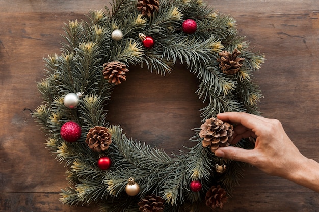 Persona che decora la corona di Natale