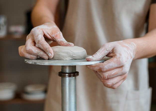 Persona che fa una pentola di creta nel suo laboratorio