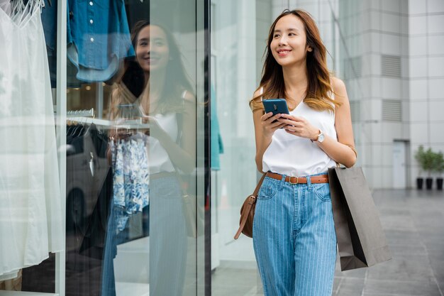 Persona che guarda il suo telefono mentre si trova contro un muro della città