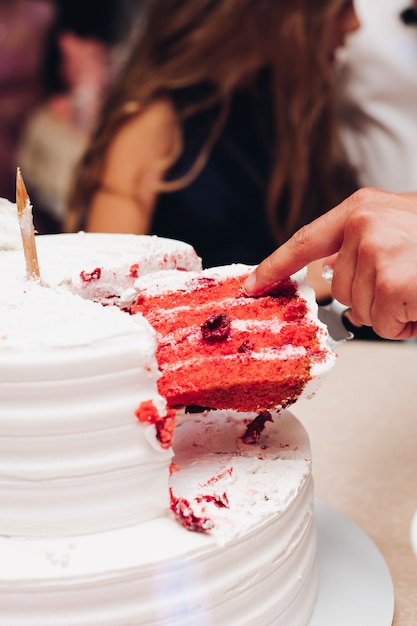 Persona che prende una fetta di torta di velluto rosso.