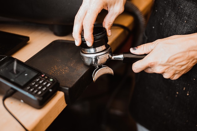 Persona che prepara il caffè fresco con la macchina della carruba?