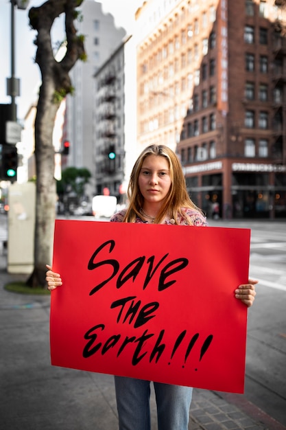 Persona che protesta con il cartello in città per la giornata mondiale dell'ambiente