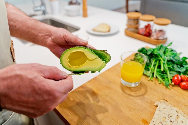 Persona che taglia un avocado in cucina.