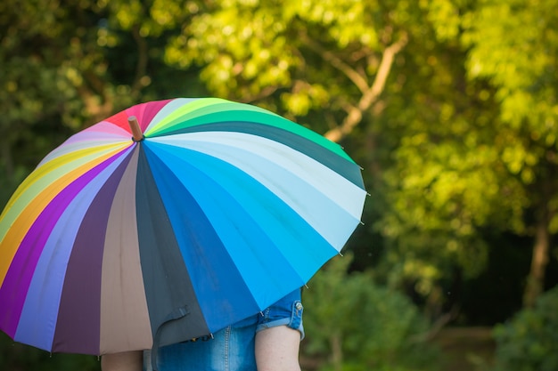 Persona che tiene un ombrello arcobaleno