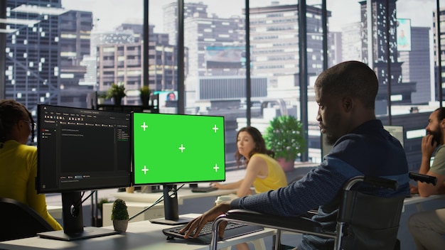 Persona con disabilità in sedia a rotelle che controlla il codice sul modello di PC