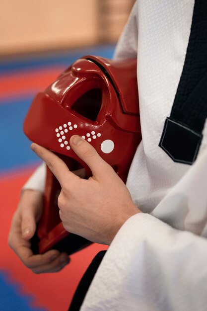 Persona con equipaggiamento protettivo che pratica taekwondo in una palestra