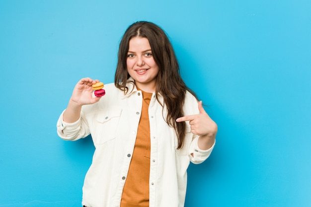 Persona dei maccheroni della tenuta della giovane donna che indica a mano una camicia