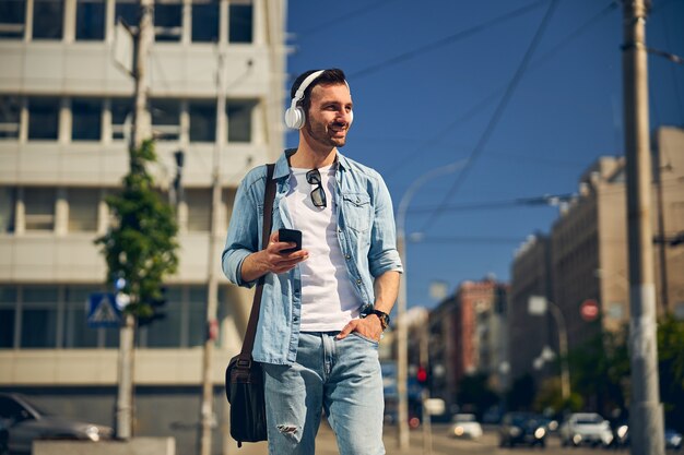 Persona di sesso maschile barbuta contentissima che sorride mentre cammina da sola per strada alone