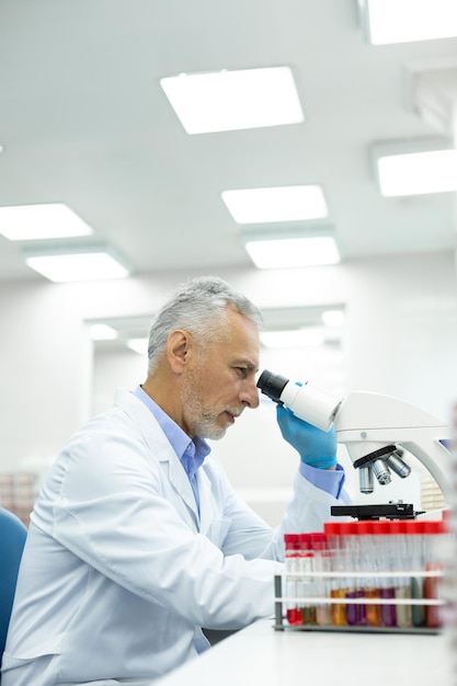 Persona di sesso maschile senior attenta che lavora in laboratorio