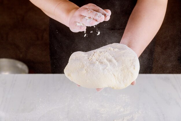 Persona impastare la pasta della pizza nelle mani per fare la pizza