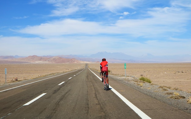 Persona in bicicletta sulla strada delle Highland del deserto di Atacama nel Cile settentrionale del Sud America