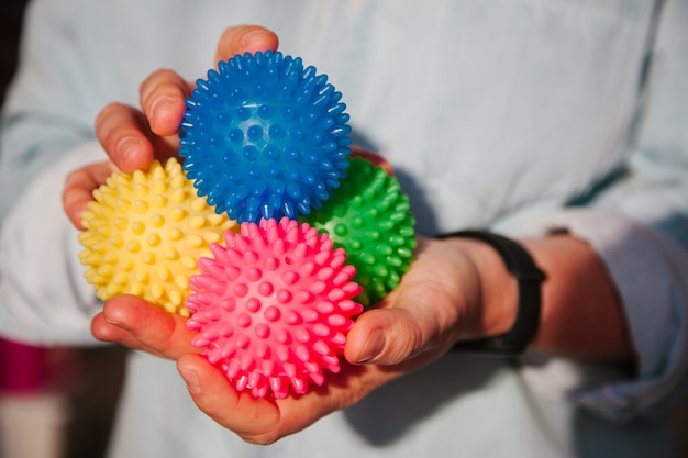 Persona in possesso di palline colorate per terapia fisica Concetto di terapia di digitopressione Sujok Palle Sujok nelle mani