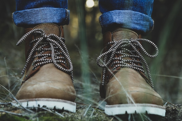 Persona in stivali e jeans. Passeggiata nella foresta