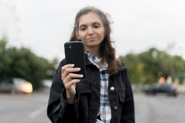 persona nella piattaforma di social media online che tiene il cellulare con lo smartphone all'aperto