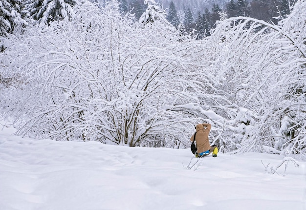 persona sconosciuta e irriconoscibile scatta una foto della foresta invernale