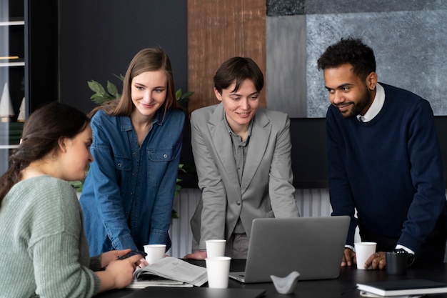 Persona trans che lavora in ufficio con i colleghi