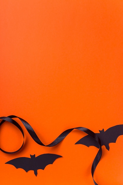 Personaggi e accessori neri di Halloween su una superficie arancione luminosa
