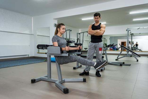 Personal trainer che lavora con una donna giovane e bella