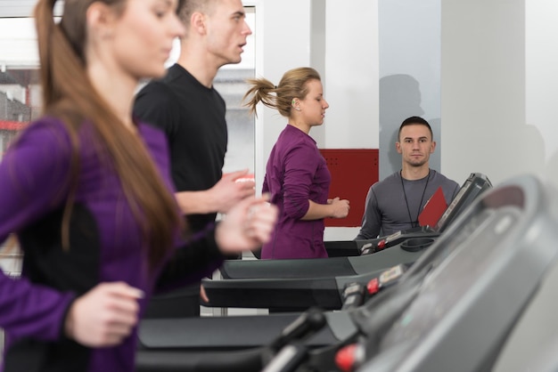 Personal Trainer e cliente in palestra sui tapis roulant