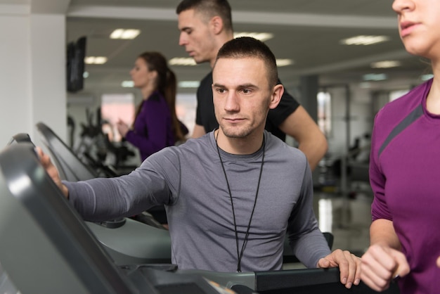 Personal Trainer e cliente in palestra sui tapis roulant