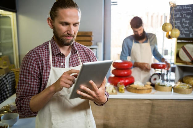 Personale attento che utilizza tavoletta digitale al banco