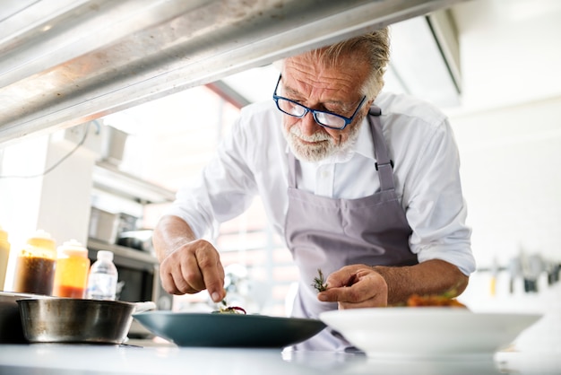 Personale della cucina che decora il piatto cucinato