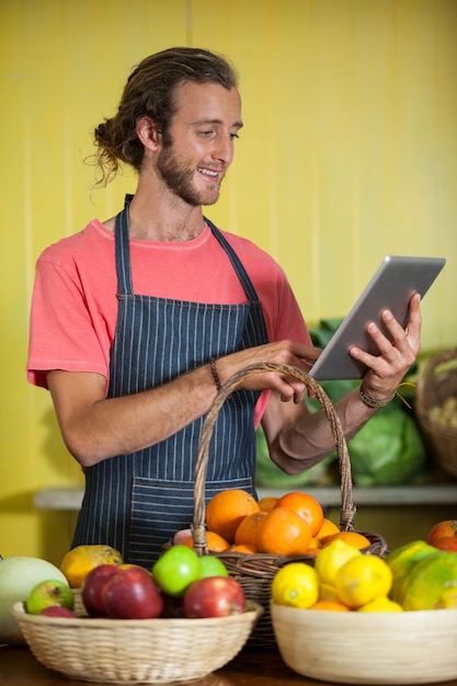 Personale maschile sorridente utilizzando la tavoletta digitale nella sezione organica