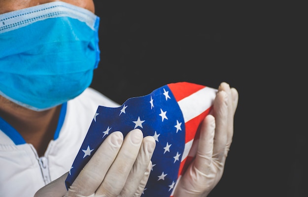 Personale medico che indossa una maschera e tiene la bandiera americana